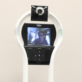 The display of a VGo robot showing a woman smiling and waving.